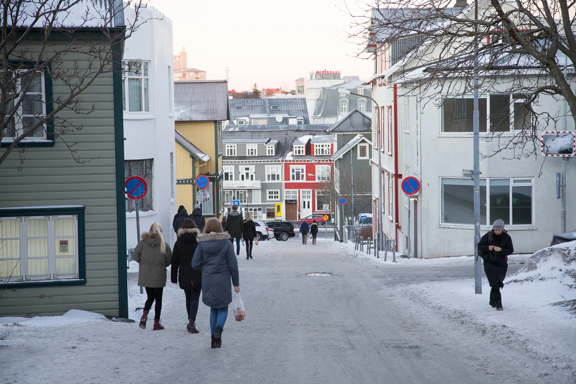 Pedestrians walk along a snow covered street in the shopping district of central Reykjavik, Iceland.