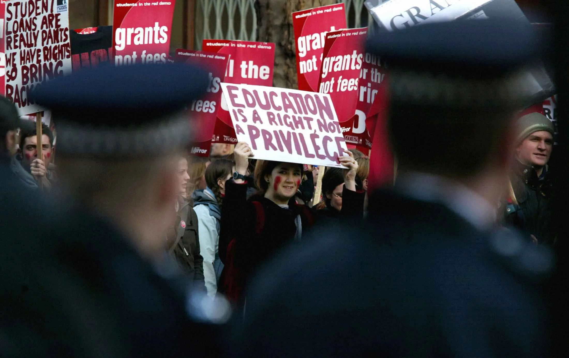 A student carries a banner calling for free education while participating in a demonstration in London
