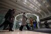 Visitors walk past an electronic ticker standing above the trading floor at the Tokyo Stock Exchange (TSE), operated by Japan Exchange Group Inc. (JPX), in Tokyo, Japan, on Friday, Feb. 9, 2018. The Topix index headed for its worst week in two years following a meltdown in U.S. equities amid concern rising interest rates will damp economic growth.