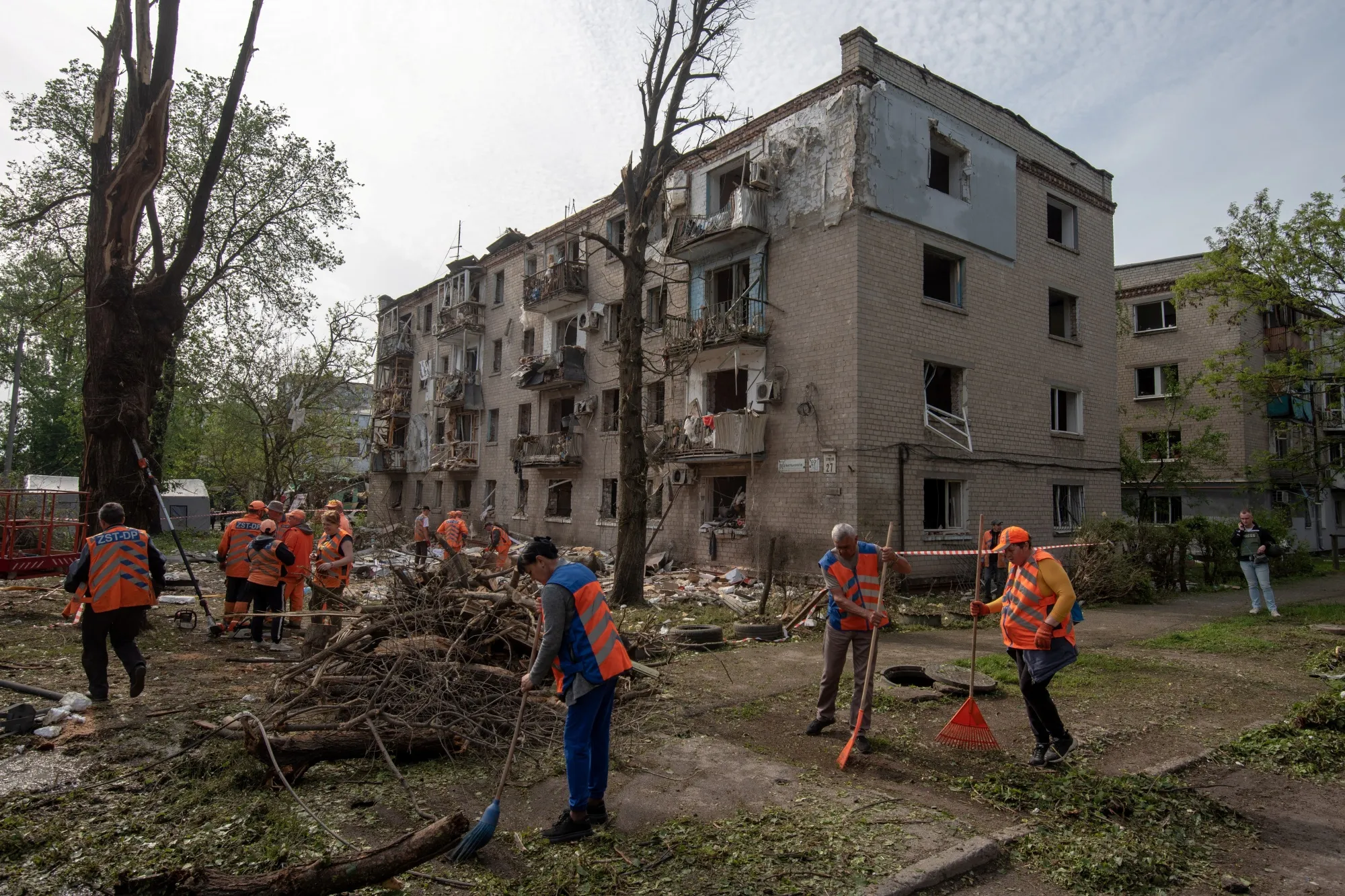 Municipal workers clean debris in the courtyard of a damaged residential building following an air attack in Dnipro, Ukraine, on May 18.