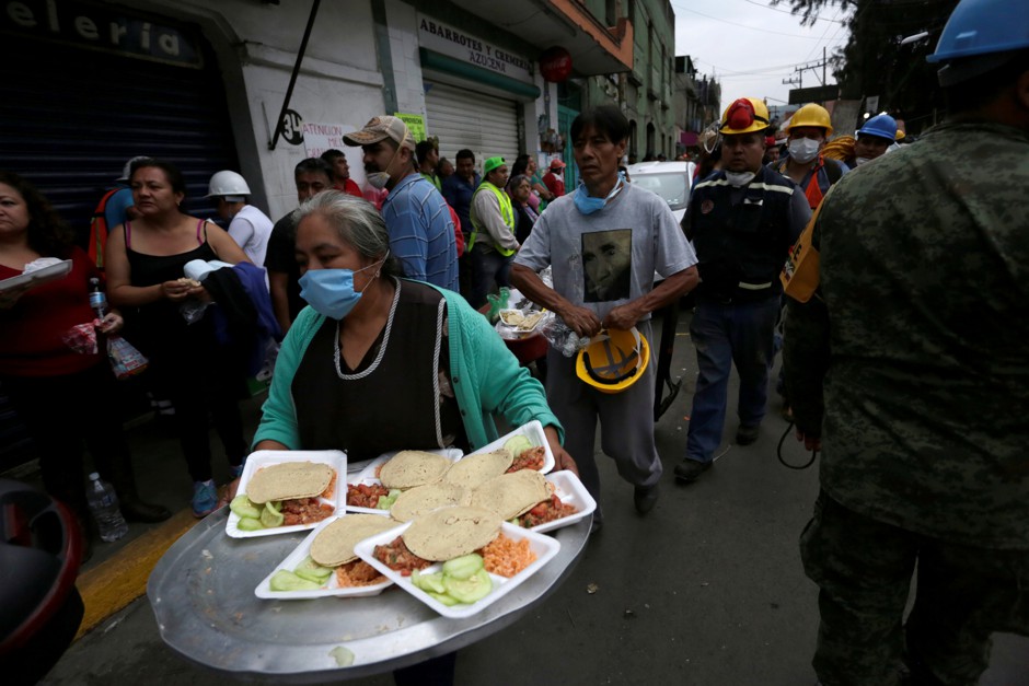 A woman delivers food to volunteers and rescue teams after an earthquake hit Mexico City.