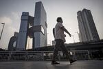 A pedestrian walks past Tencent Holdings Ltd.'s headquarters, left,&nbsp;in Shenzhen, China.