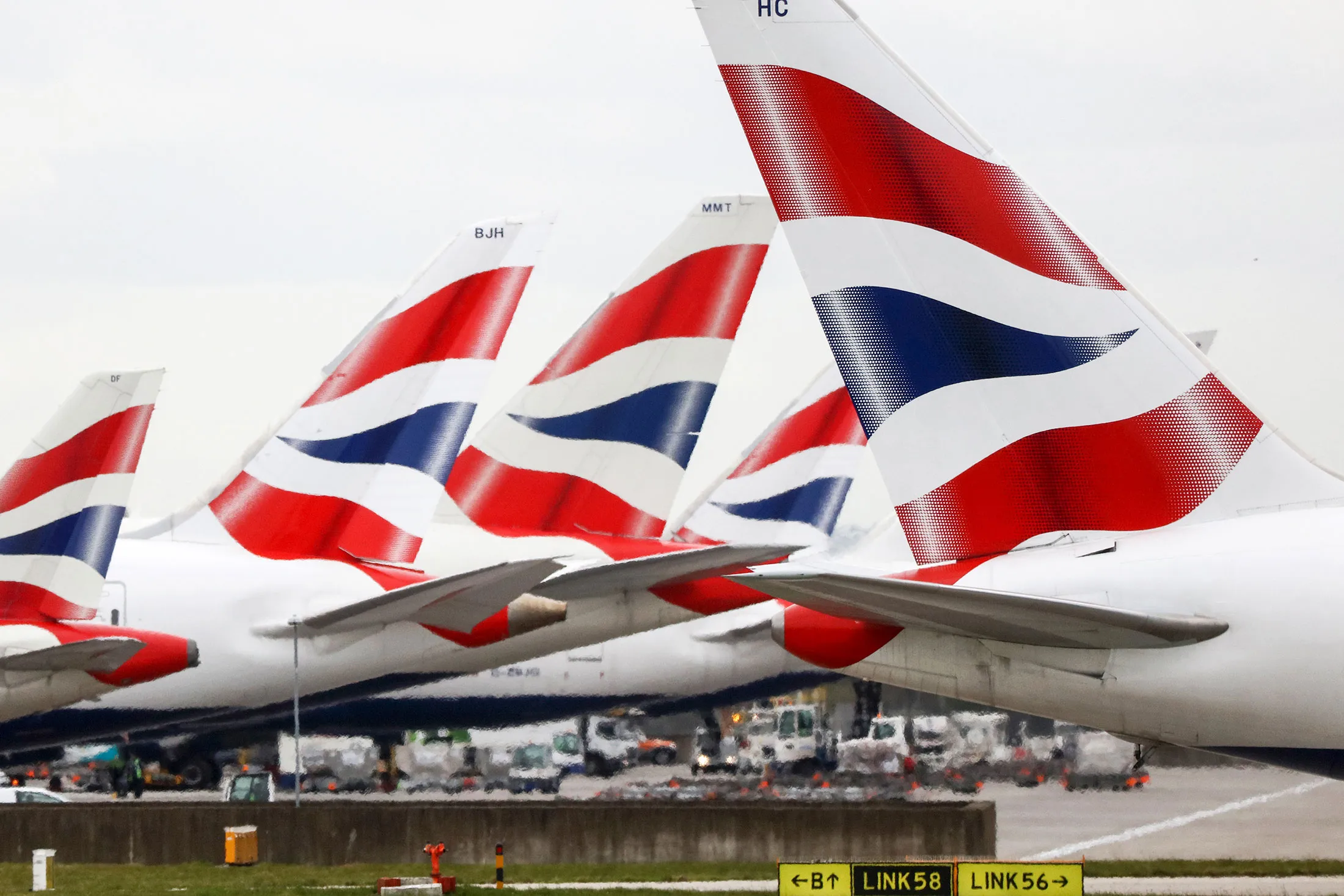 A passenger aircraft operated by British Airways, a unit of International Consolidated Airlines Group SA (IAG), taxis past the tail fins of other British Airways aircraft near Terminal 5 at Heathrow airport, in London, U.K., on Tuesday, March 29, 2016. IAG provides international and domestic air passenger and cargo transportation services.
