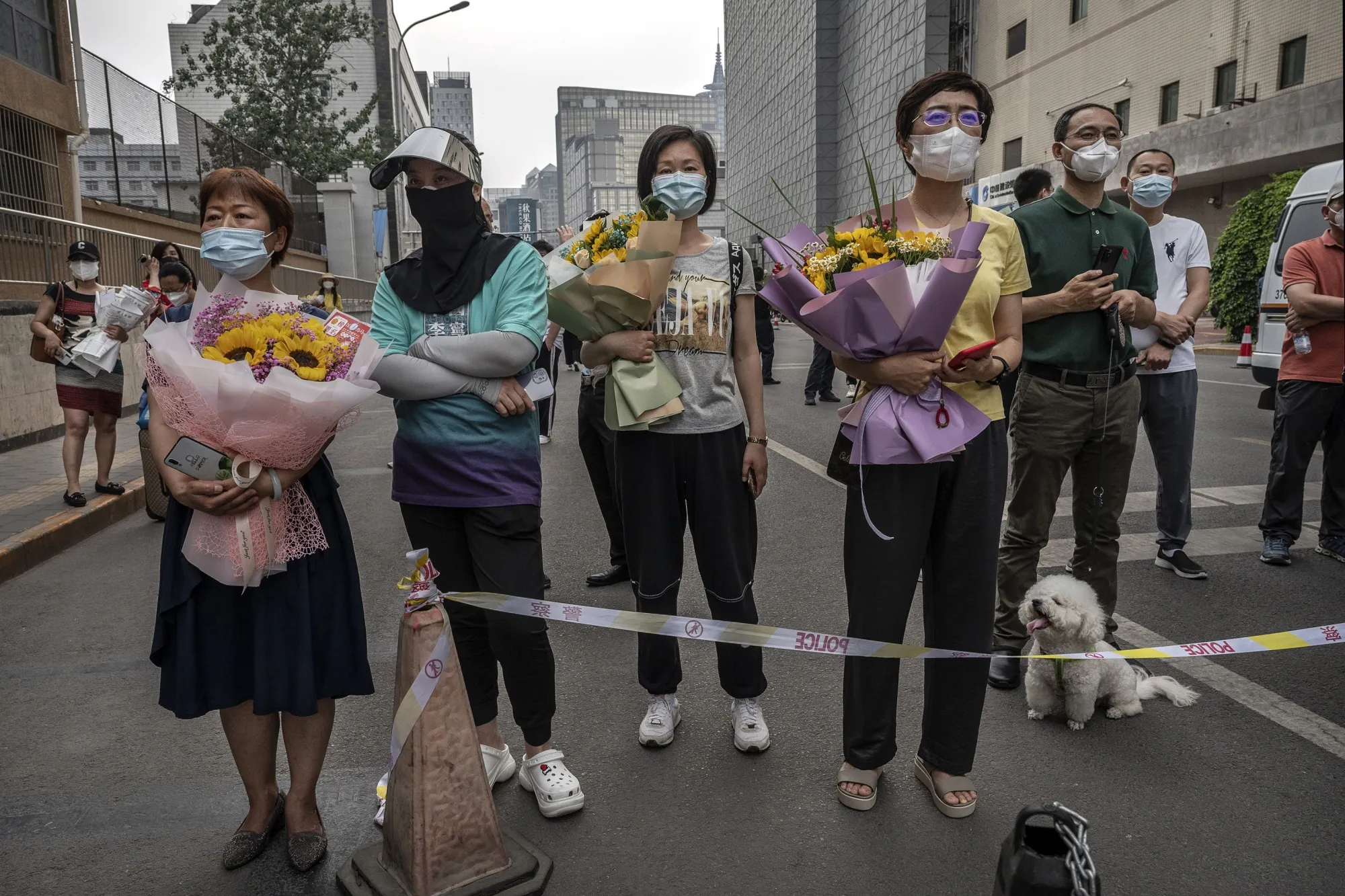 People wait for students to emerge after finishing the final day of the National College Entrance Examination in Beijing on June 10.