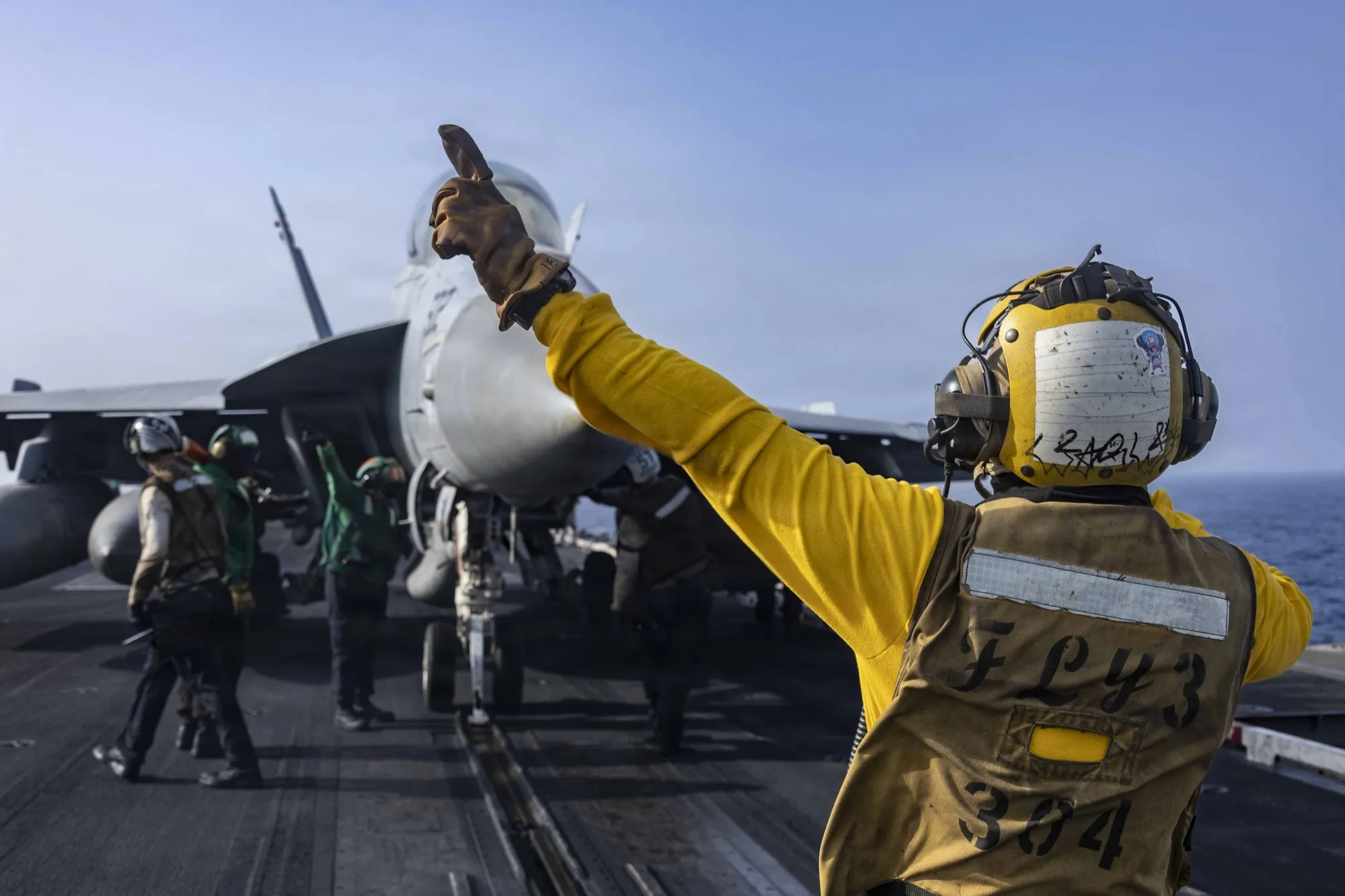 A fighter jet prepares to launch from the flight deck of USS Abraham Lincoln on June 25.