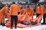 Search and rescue team members carry debris recovered from the SJ182 crash site on the dockside at Tanjung Priok Port in Jakarta, Indonesia on Jan. 10.