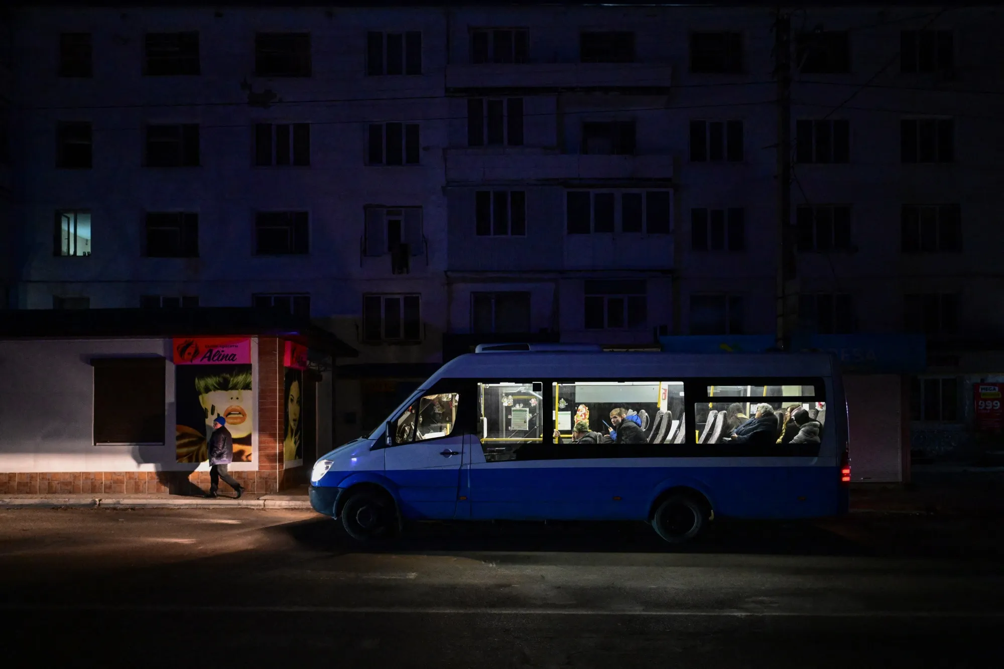A man walks next to a vehicle&nbsp;during a programmed power shortage in Varnita, Moldova, on Jan. 17.&nbsp;