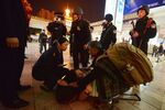 Chinese armed police and officials help an injured woman at the scene of the terror attack at the main train station in Kunming, Yunnan Province on March 2, 2014