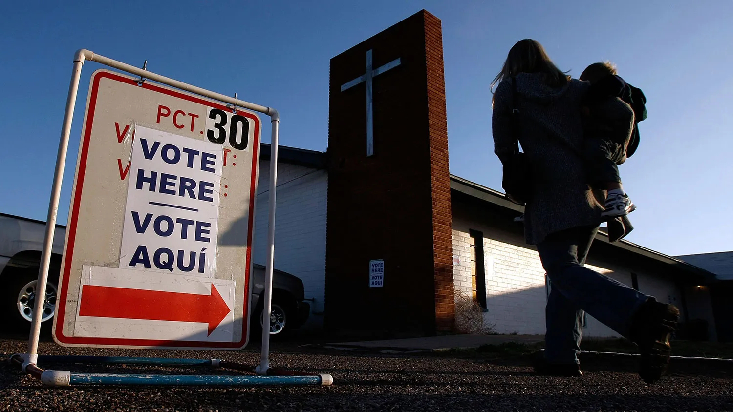 A voter carries her child on her hip as she enters the First Baptist Church polling station on Feb. 5, 2008, in Maricopa, Arizona.
