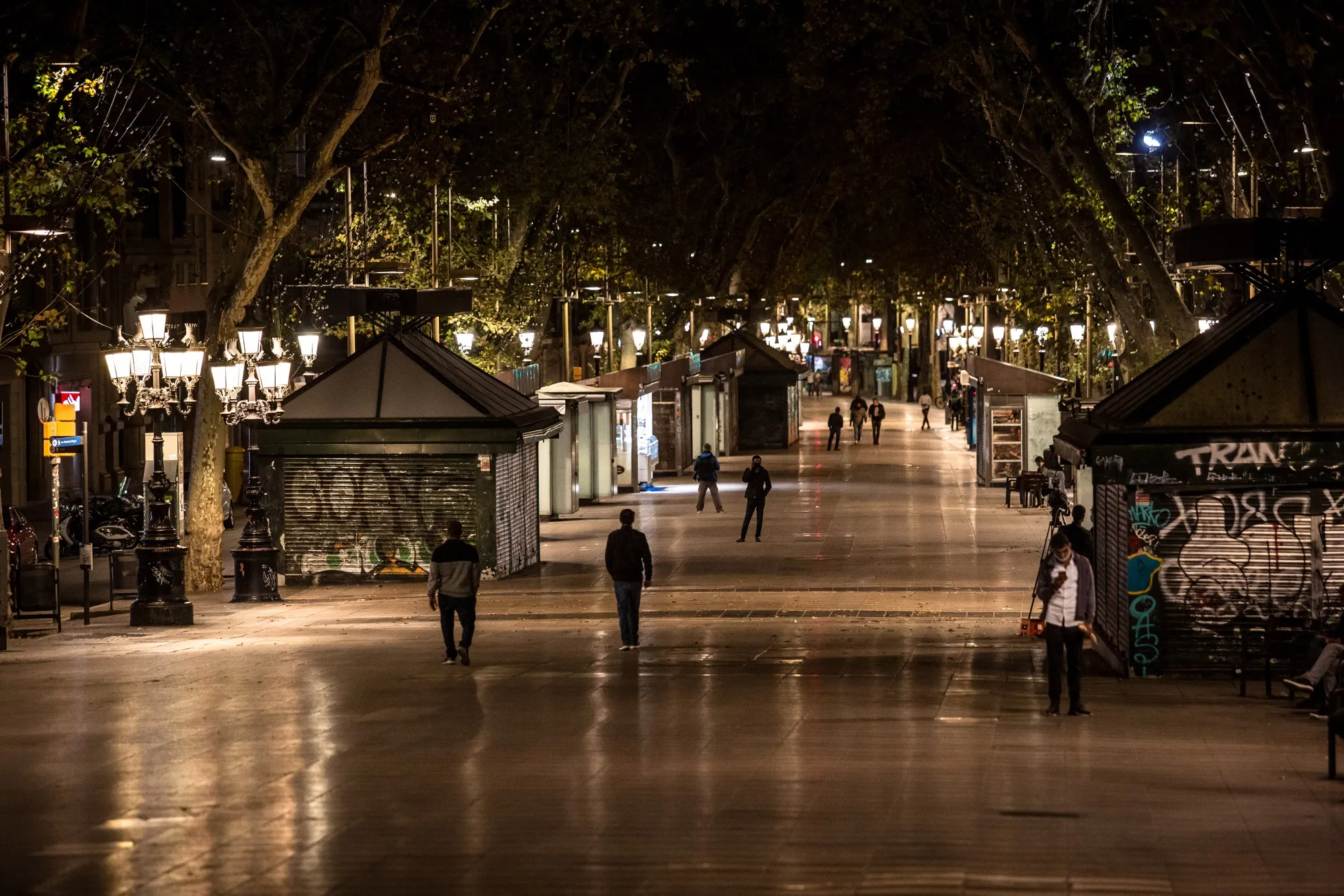 Pedestrians walk along Las Ramblas during a curfew in Barcelona.