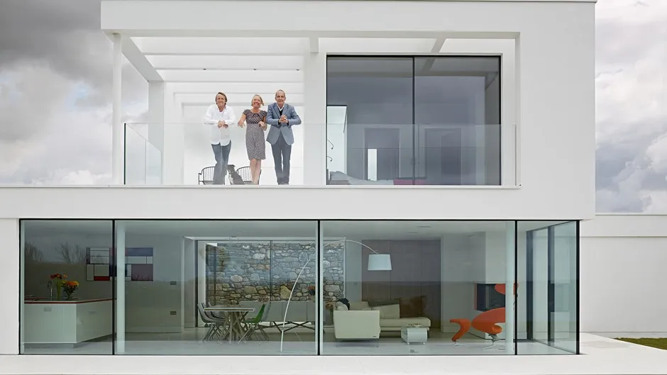 Host Kevin McCloud, right, with Rob Hodgson and Kay Ralph at their cliffside house in Wales