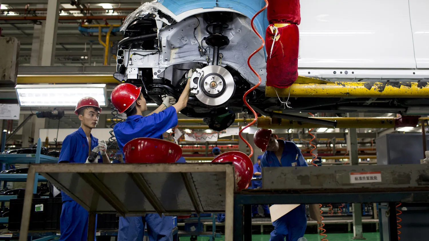 Employees install brake pads on a BYD Co. S6 sport-utility vehicle (SUV) at the company's assembly plant in the Pingshan district of Shenzhen, China,
