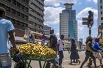 Pedestrians walk by main streets in the Harare's Central Business District.