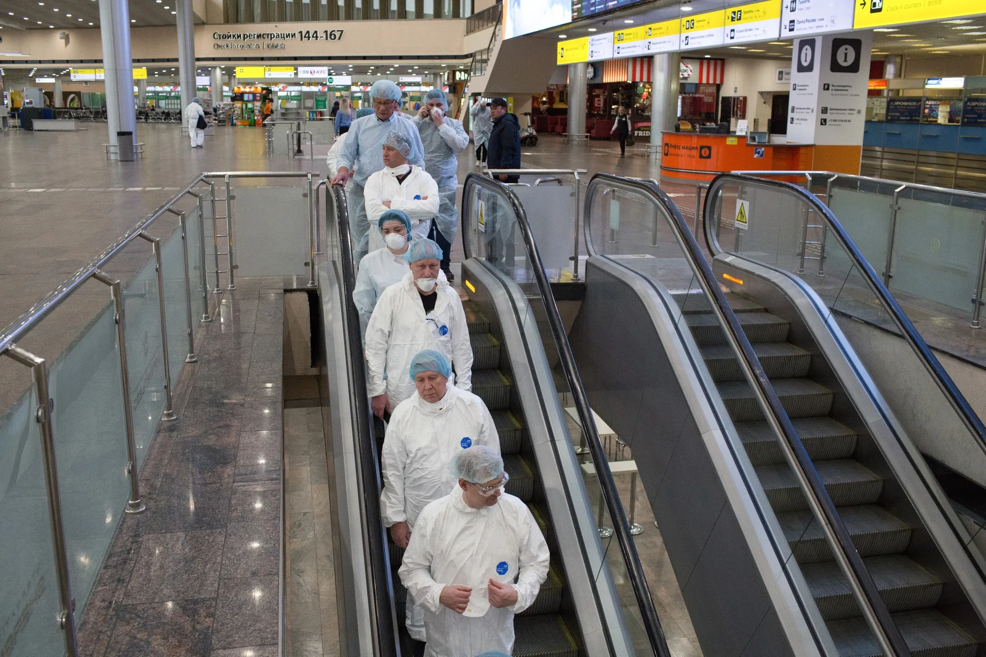 Health workers pass through the passenger arrivals terminal at Sheremetyevo International Airport in Moscow on Feb. 26.