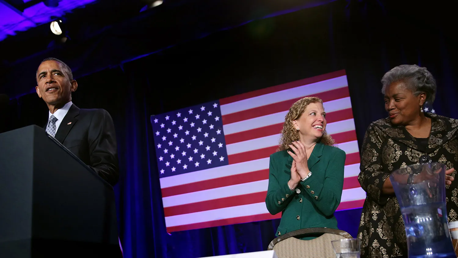 WASHINGTON, DC - FEBRUARY 20: (AFP OUT) U.S. President Barack Obama speaks (L) as Democratic National Committee Chair and Rep. Debbie Wasserman Schultz (D-FL) (2nd R) and Vice Chair for Voter Registration and Participation Donna Brazile (R) share a moment during the General Session of the 2015 DNC Winter Meeting February 20, 2015 in Washington, DC. President Obama addressed the event and participated in a roundtable discussion.
