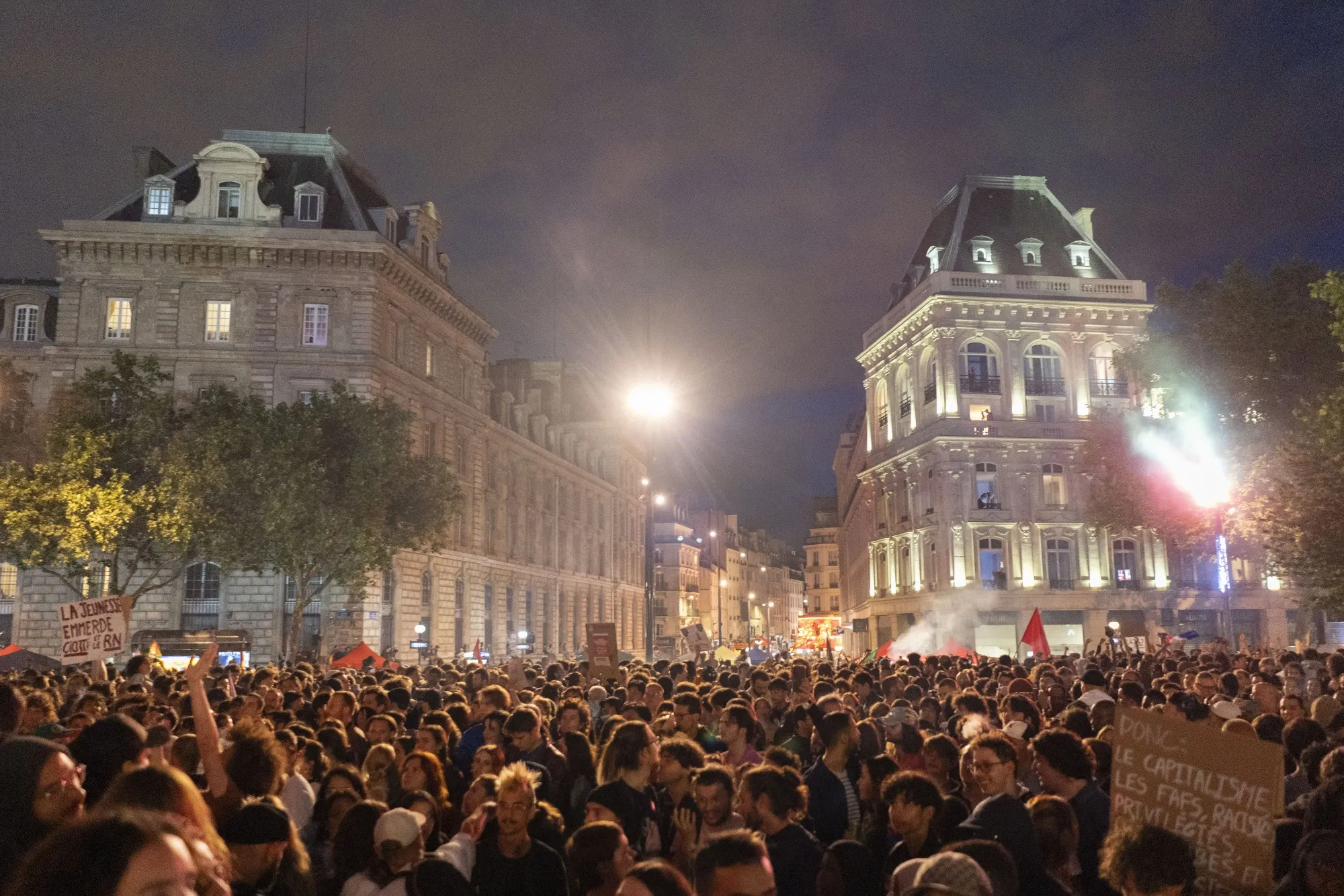 People in Paris celebrate following the second round of French legislative elections on Sunday.