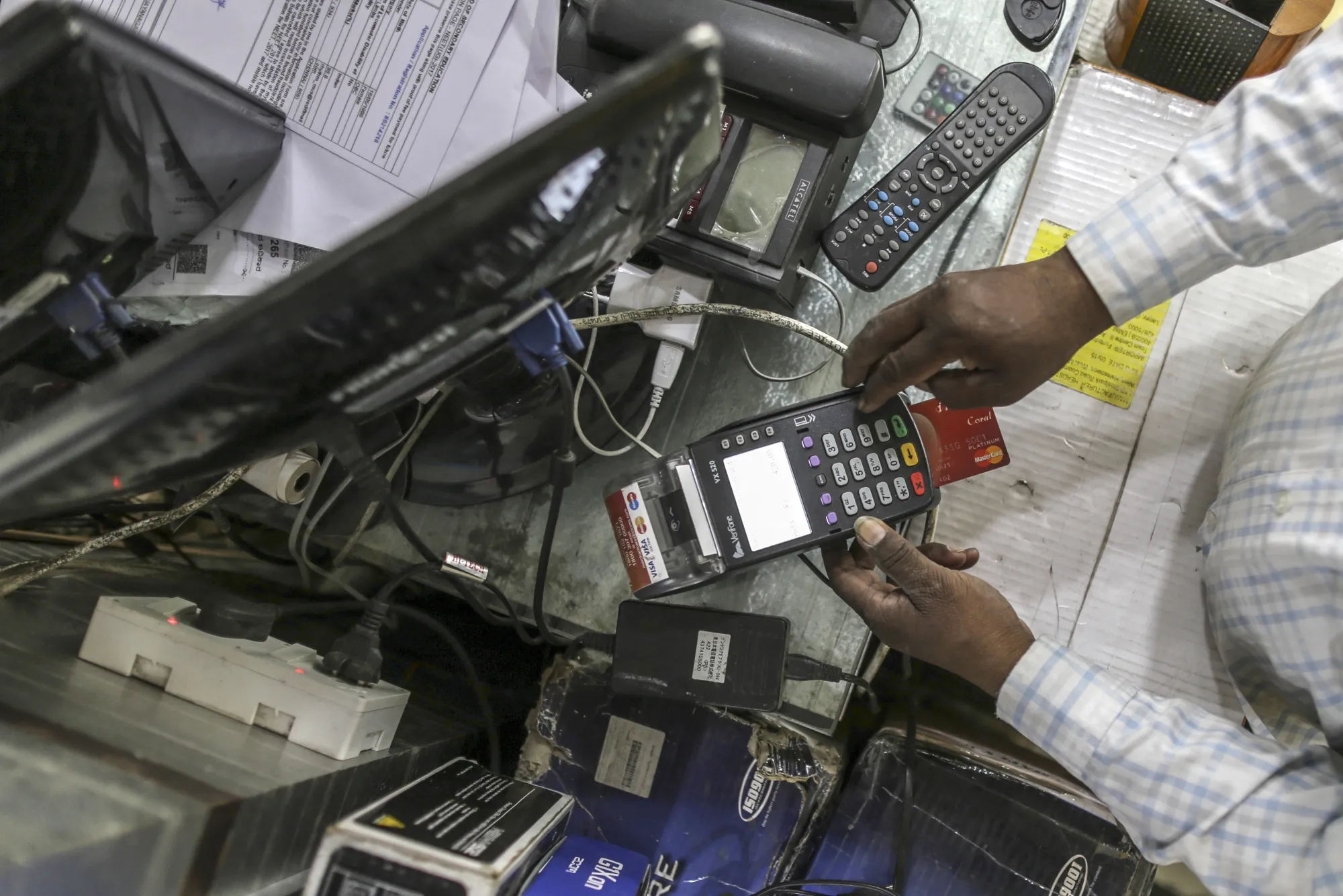 An employee operates a electronic payment terminal at a store in Bengaluru, India.