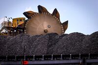 A bucket-wheel reclaimer stands next to a pile of coal at the Port of Newcastle in Australia.