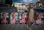 A woman walks next to election posters in Stockholm Sept. 1.