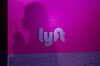 The shadow of an attendee is seen on Lyft Inc. signage.