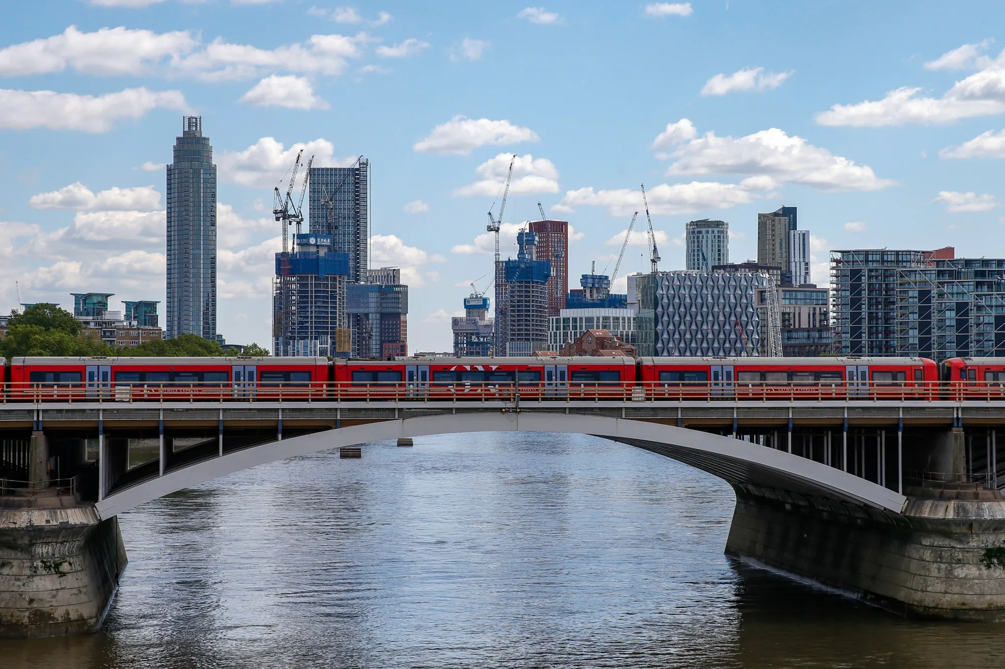 A train crosses the River Thames in view of construction work in the Nine Elms and Vauxhall districts in London, on May 12.