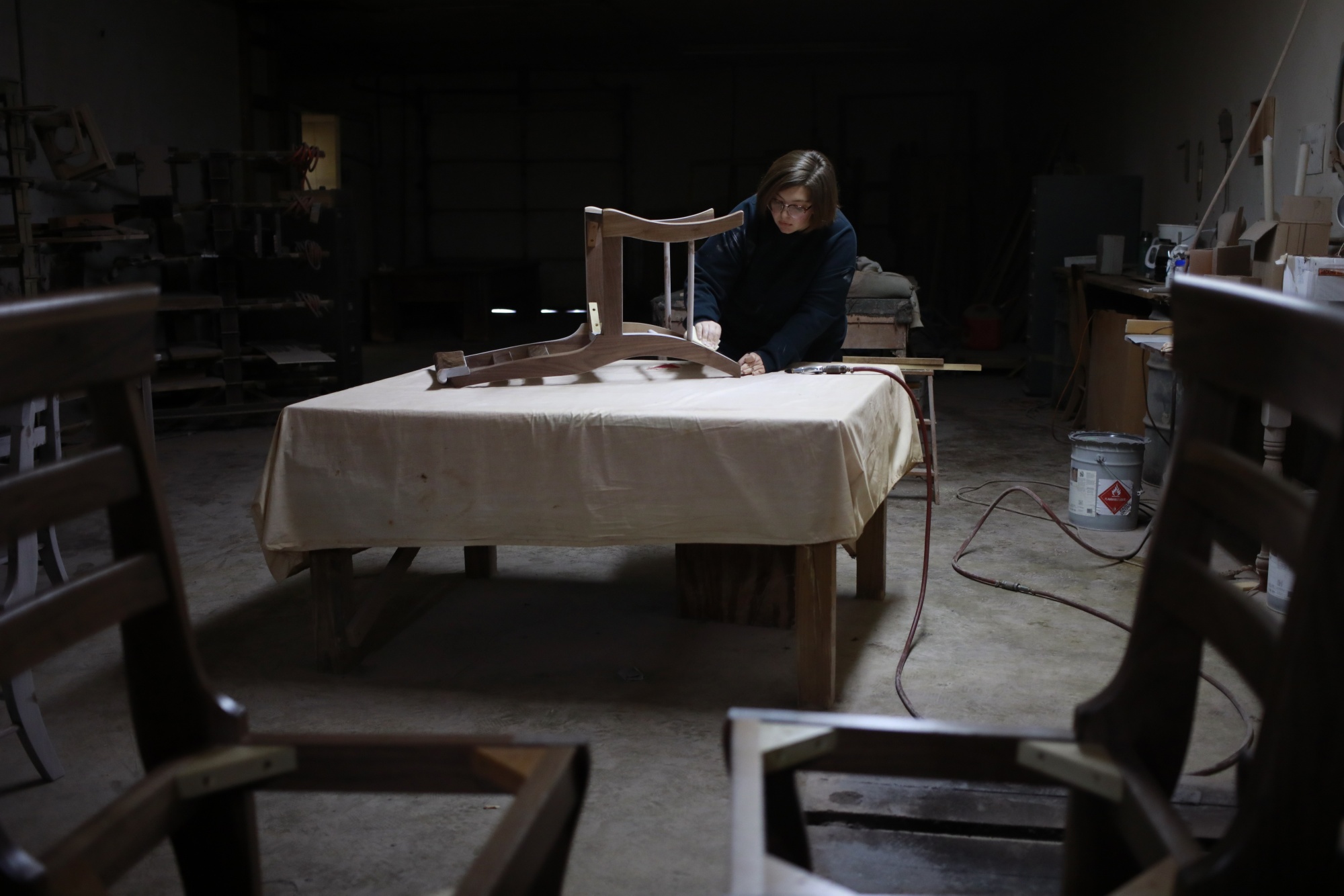 A factory worker sandpapers a handmade chair at a wood shop in Auburn, Kentucky.