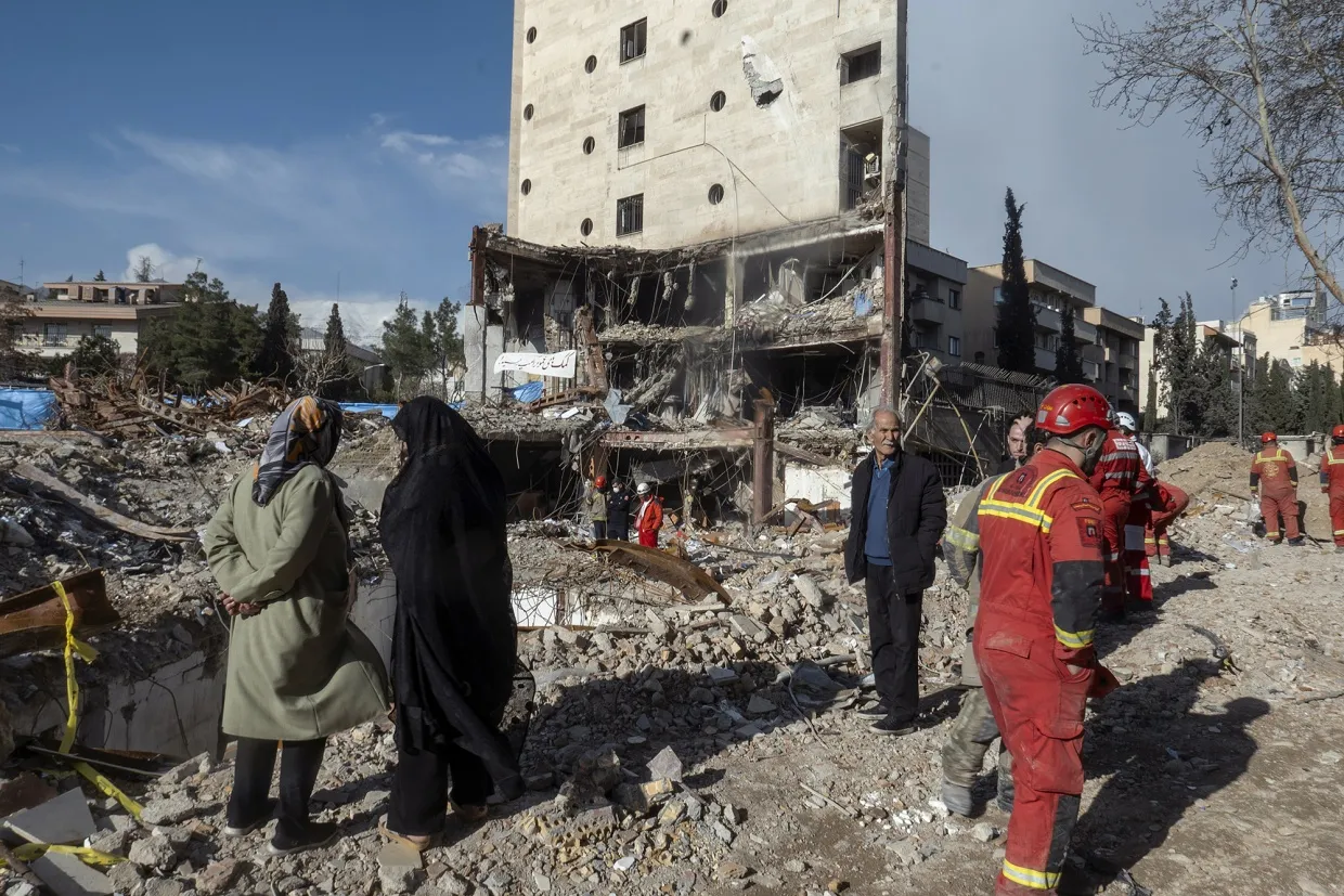 Civilians and emergency workers near the remains of a residential and commercial building in the Shahrak-e Gharb neighbourhood of Tehran on March 21.