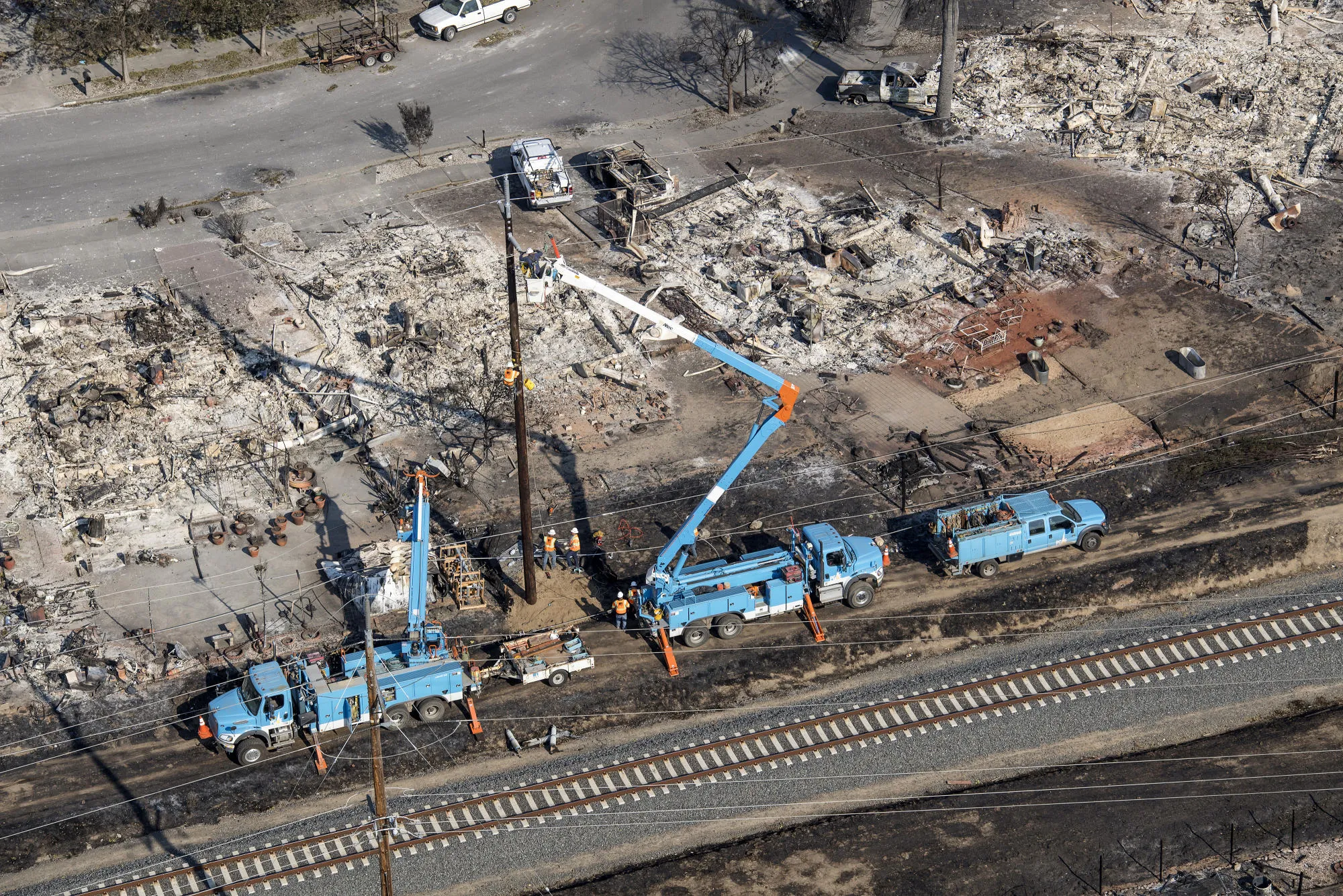 PG&E employees work to fix downed power lines burned by wildfires in 2017.