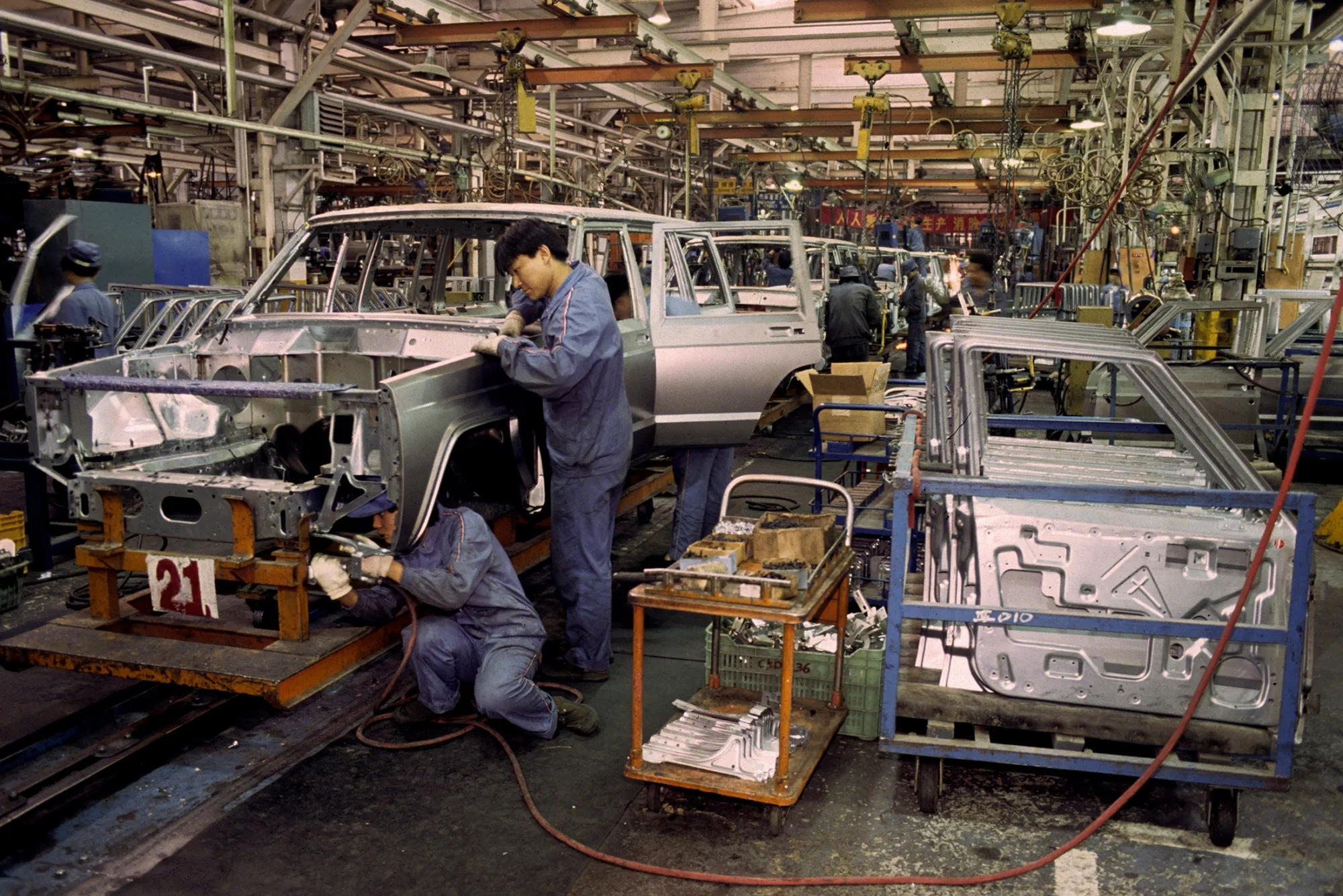 Workers assemble Jeep vehicles on a factory line at a Chrysler joint venture plant in Beijing, China, in 1993.