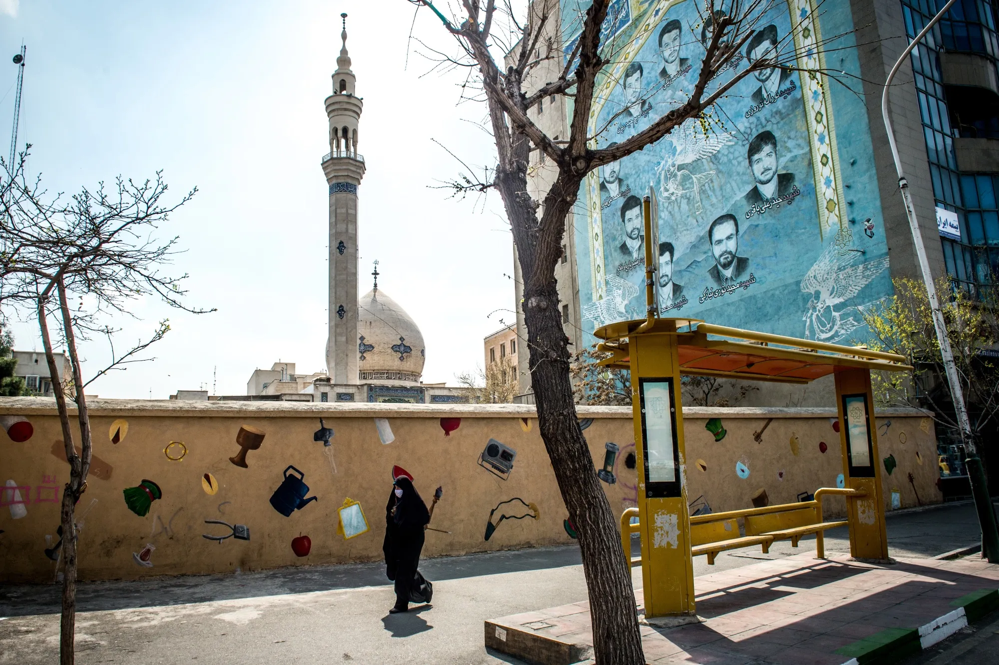A pedestrian wears a protective face mask while walking in central Tehran on March 15.