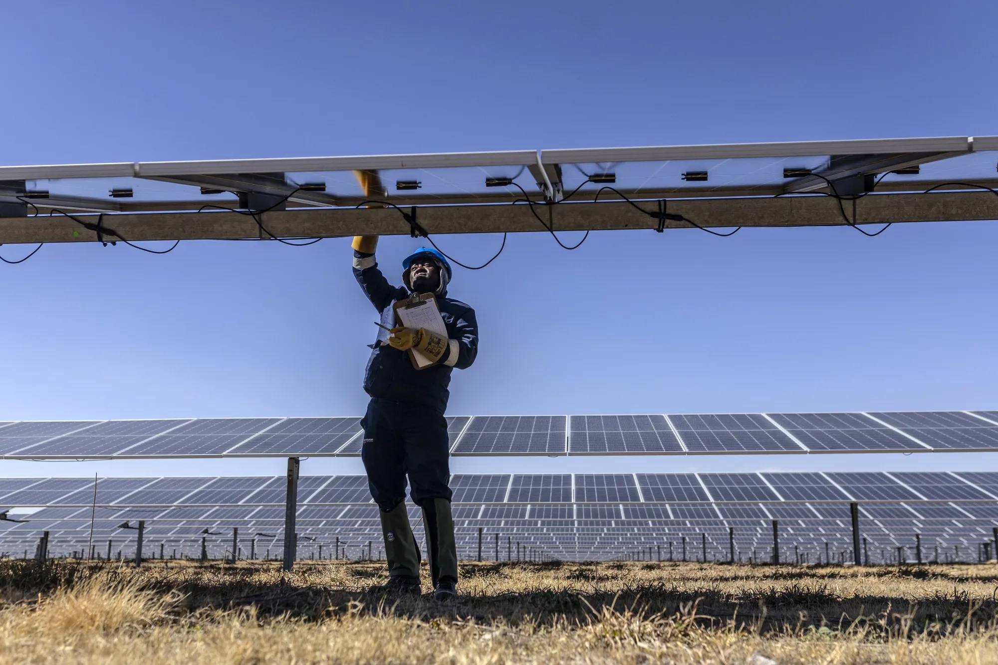 A worker inspects panels at a solar plant&nbsp;in Evander, South Africa.