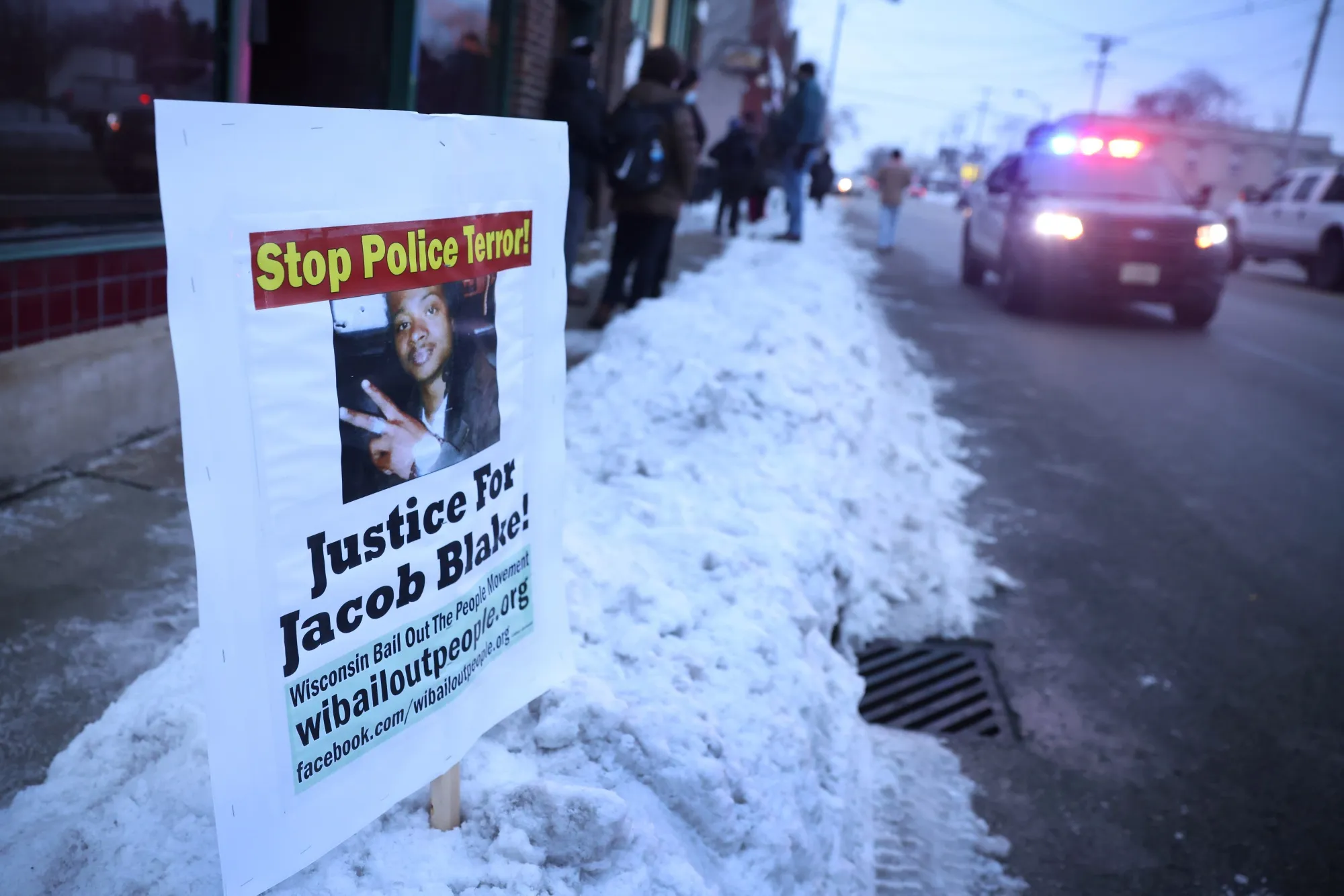 A police car drives past a sign showing support for Jacob Blake Jr.&nbsp;in Kenosha, Wisconsin, on Jan. 4.