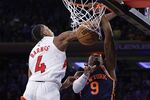 New York Knicks guard RJ Barrett (9) dunks in front of Toronto Raptors forward Scottie Barnes (4) at the end of the second half of an NBA basketball game Monday, Jan. 16, 2023, in New York. (AP Photo/Adam Hunger)