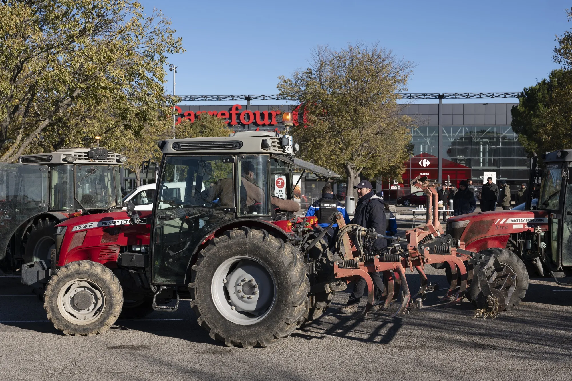 Farmers block the parking area of a Carrefour supermarket with tractors during a protest in Pertuis, France, on Nov. 22.
