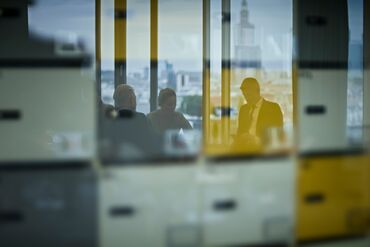 Looking at board room glass wall. Business people's reflections RF
