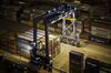 A gantry crane stands next to shipping containers stacked at the Xiamen Songyu Container Terminal at night in Xiamen, China, on Saturday, Jan. 30, 2016. The Benjamin Franklin is the largest container ship ever to have docked at a U.S. port.