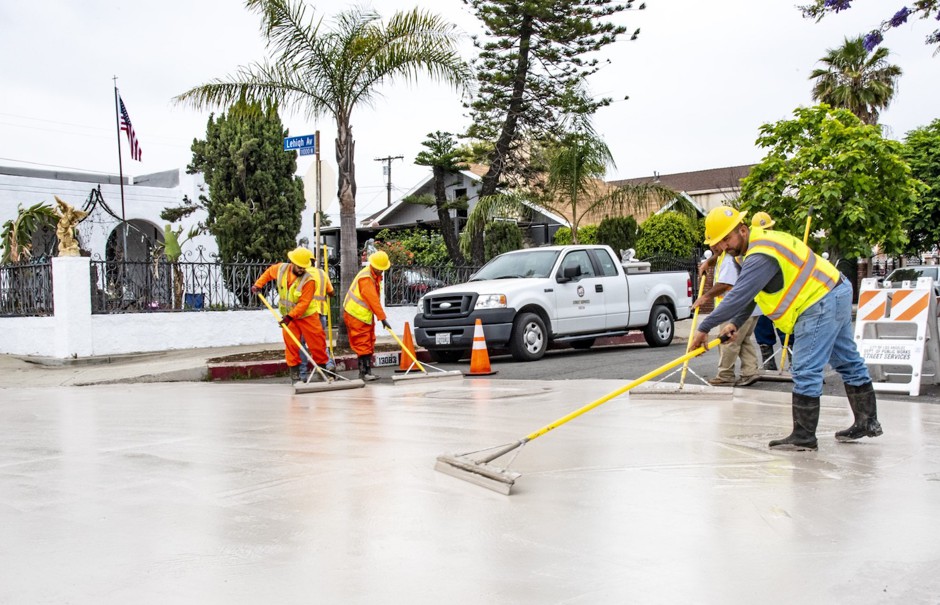 Workers apply CoolSeal to a street in Pacoima in June.
