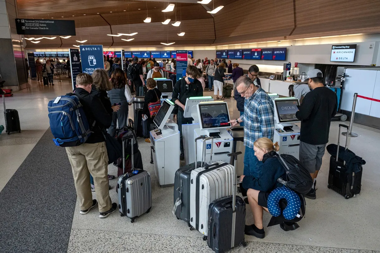 Travelers at Delta Air Lines check-in kiosks at San Francisco International Airport.