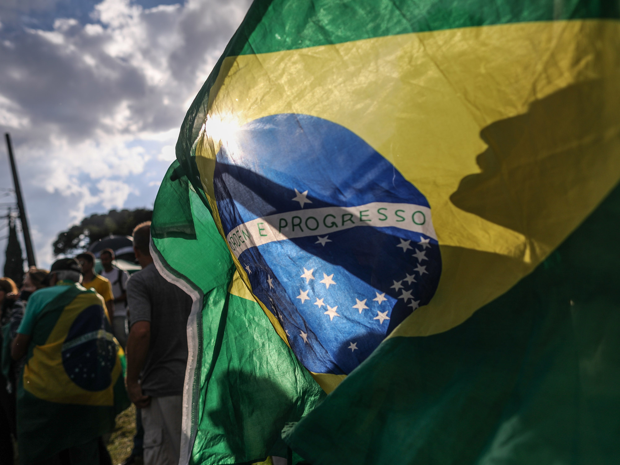 Demonstrators wave a Brazilian flag.