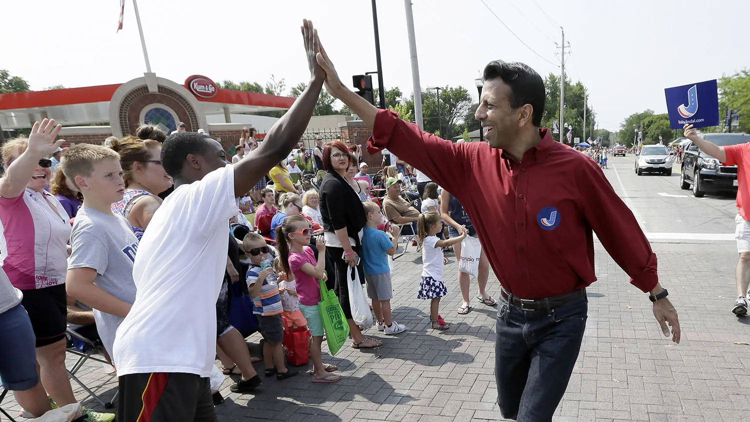Republican presidential candidate Louisiana Gov. Bobby Jindal gets a high five while walking in a Fourth of July parade, Saturday, July 4, 2015, in Urbandale, Iowa.
