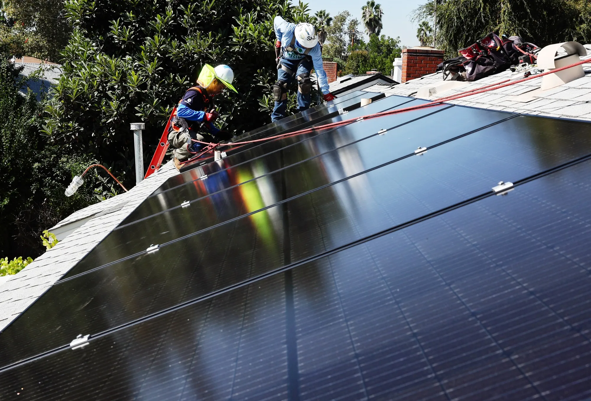 Workers install&nbsp;solar panels on the roof&nbsp;of a low-income household in Pomona, California.