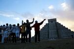 People gesture toward the Kukulkan temple in Chichen Itza, Mexico, on Dec. 21, 2012.