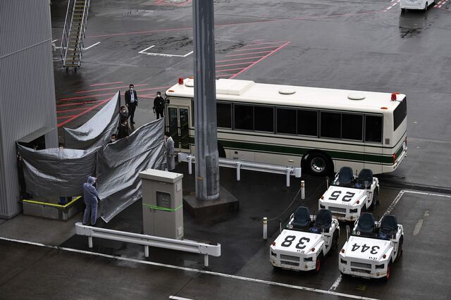 Japanese authorities prepare for the arrival of Michael and Peter Taylor at Narita airport in Japan on Mar. 2, 2021.