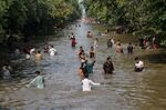 Residents in Lahore, Pakistan, cool off in a river canal as temperatures reach 40 degrees celsius on May 27, 2020.