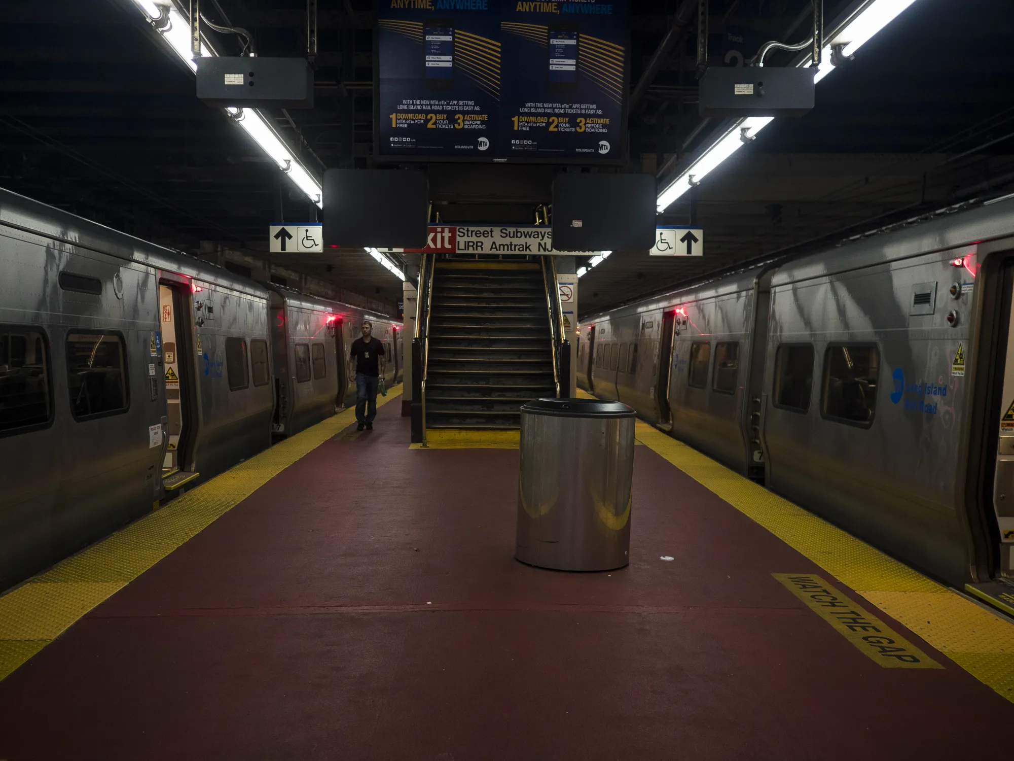Trains on a platform inside Pennsylvania Station in New York.