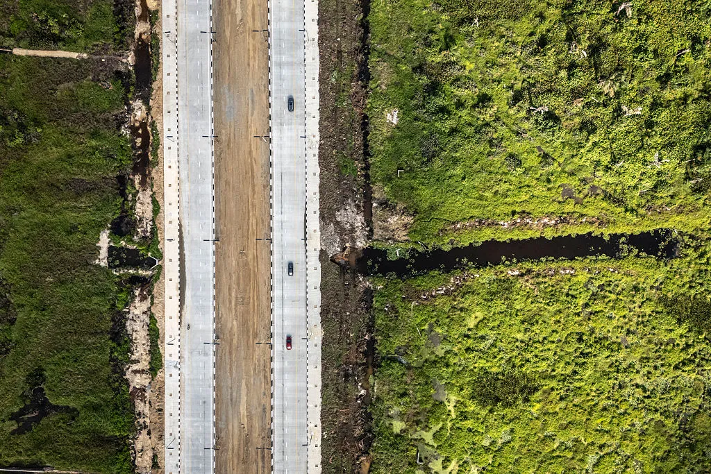 Vehicles driving along the Lagos-Calabar Coastal Highway in the outskirts of Lagos, Nigeria.