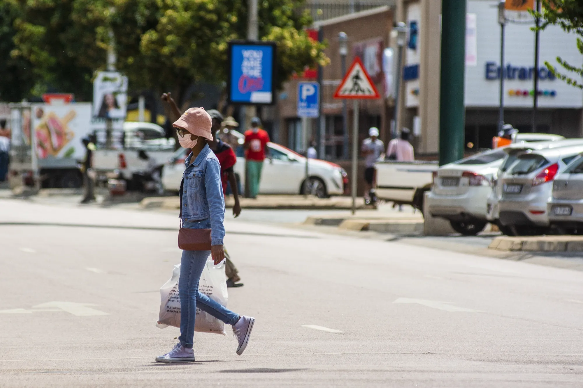 A pedestrian wearing a protective face mask crosses the street in Pretoria.