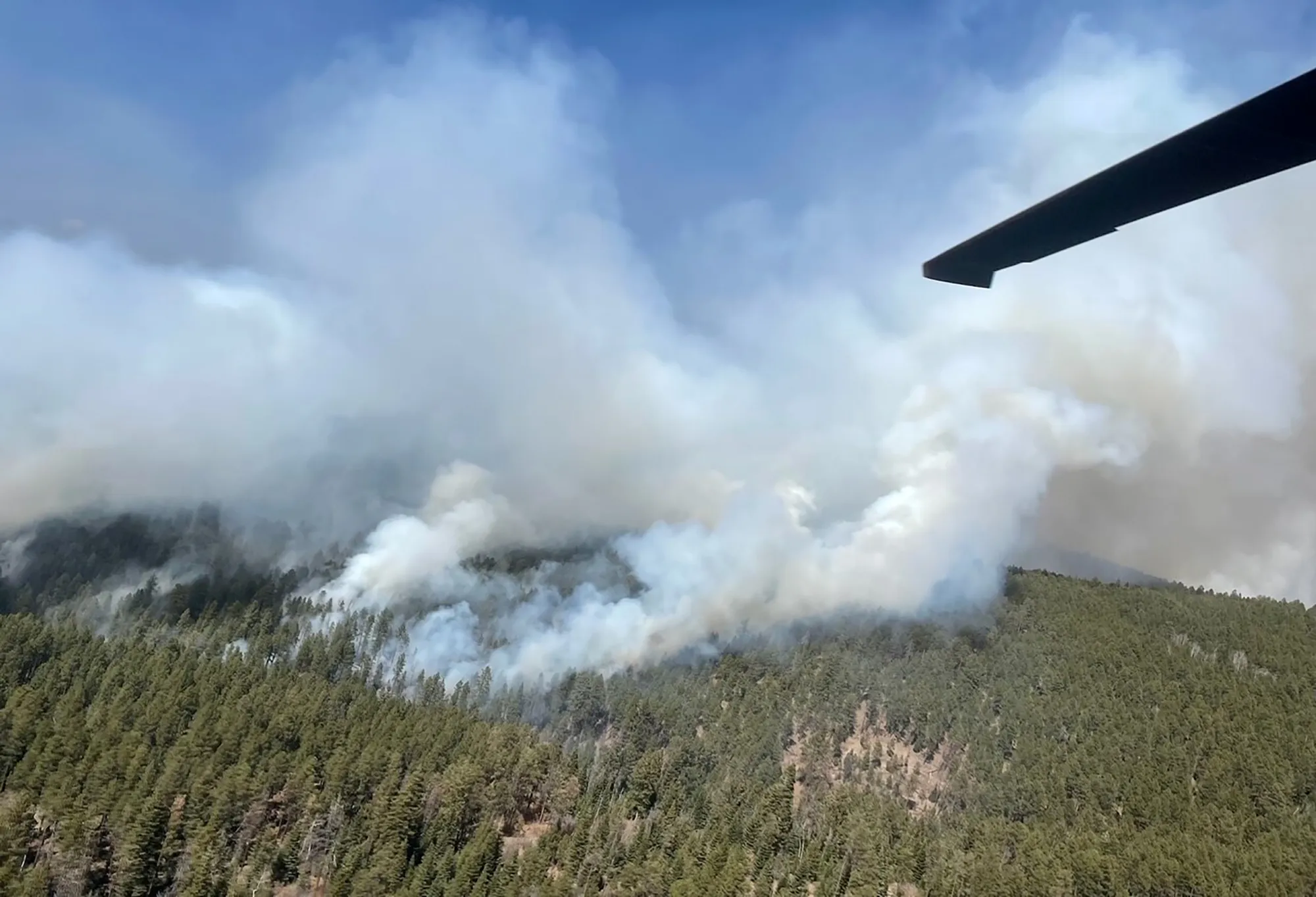 A New Mexico National Guard Aviation UH-60 Black Hawk flies as part of firefighting efforts, dropping thousands of gallons of water&nbsp;from the air on the Calf Canyon/Hermits Peak fire in northern New Mexico on&nbsp;May, 1.