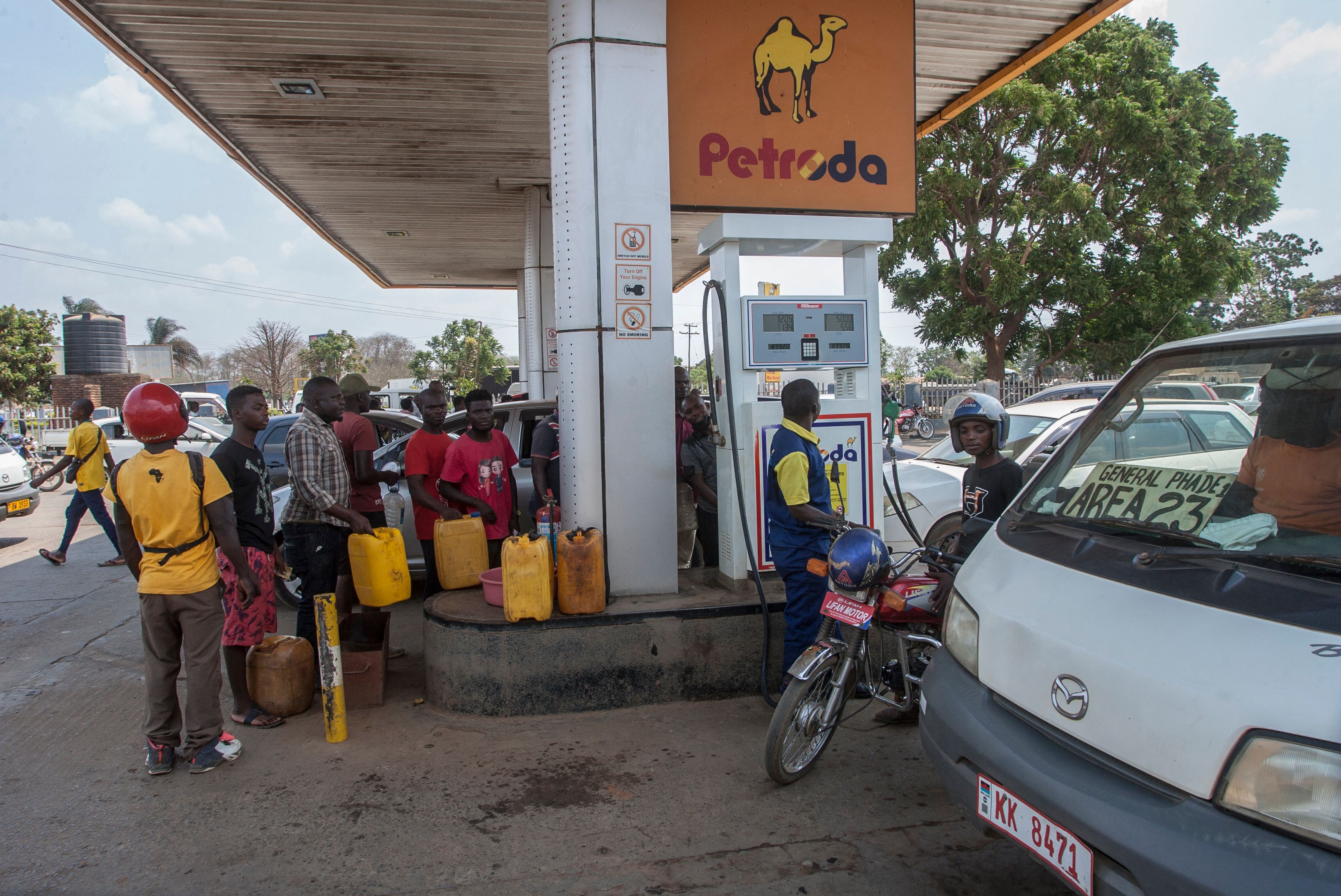 A petrol attendant fills a motorcycle with fuel at a filling station in Lilongwe, Malawi.