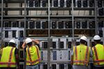 Workers install a row of Bitcoin mining machines at the Whinstone Bitcoin mining facility in Rockdale, Texas.